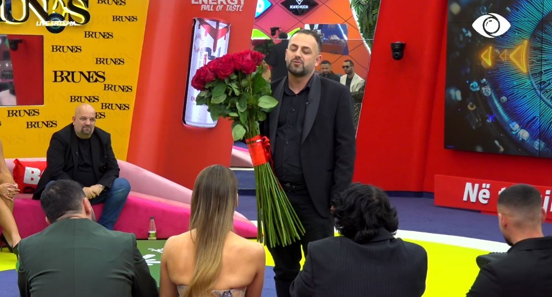 Seno futet brenda në shtëpi  i sjell buqetën e madhe me trëndafila të kuq banores dhe i shpreh pëlqimin